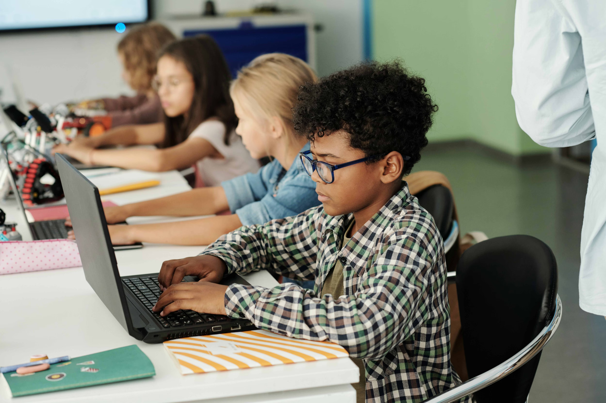 Students working at laptops in a classroom